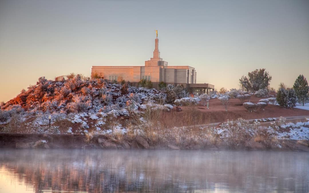 Snowflake Arizona Temple on a snowy hill across a misty pond at sunrise.