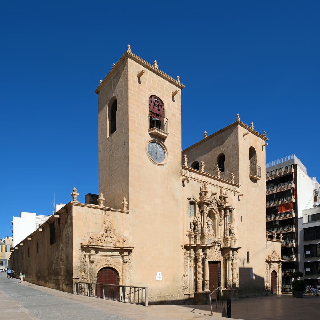 Wide-angle exterior view of the stone facade under a clear blue sky.