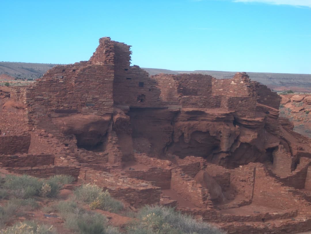 Exterior view of multi-story sandstone masonry ruins at Wupatki Pueblo.
