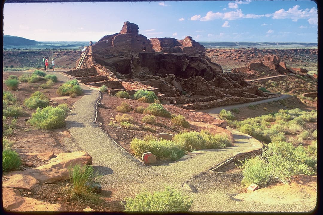 Wide-angle view of Wupatki Pueblo ruins and visitor trails in daylight.