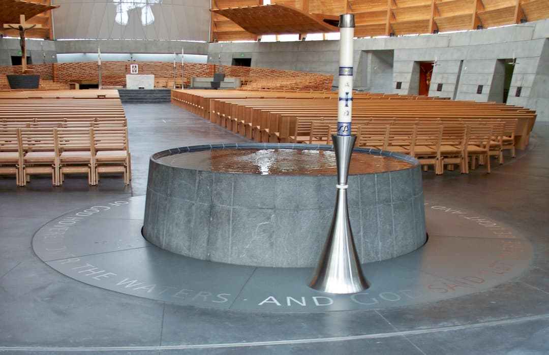 Interior view of the circular baptismal font and Paschal candle.