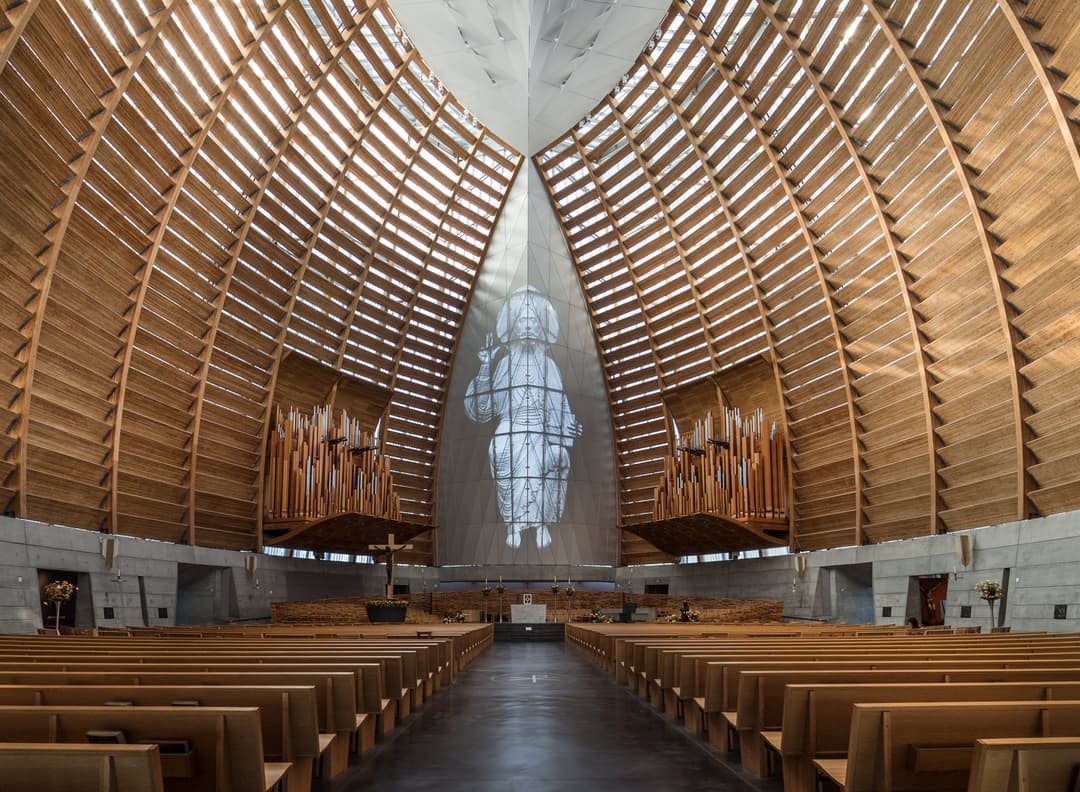 Interior view of the sanctuary looking toward the altar and timber vault.