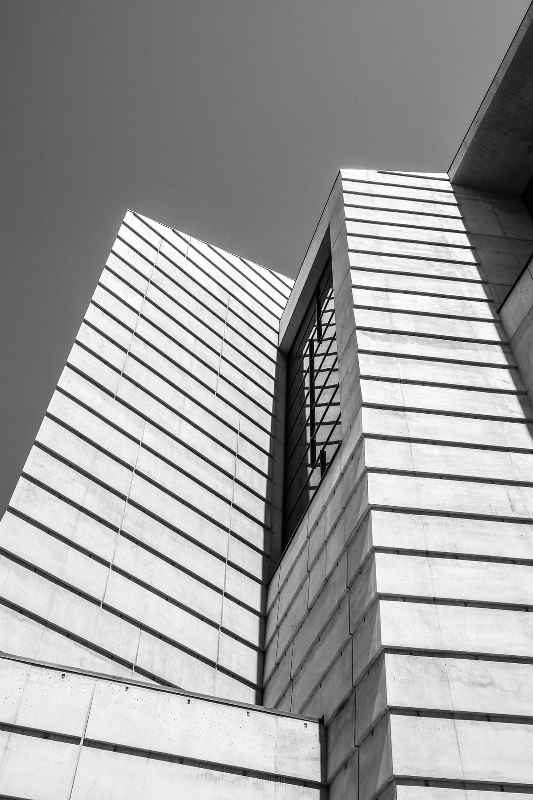 Low-angle view of the cathedral's geometric, textured concrete facade.
