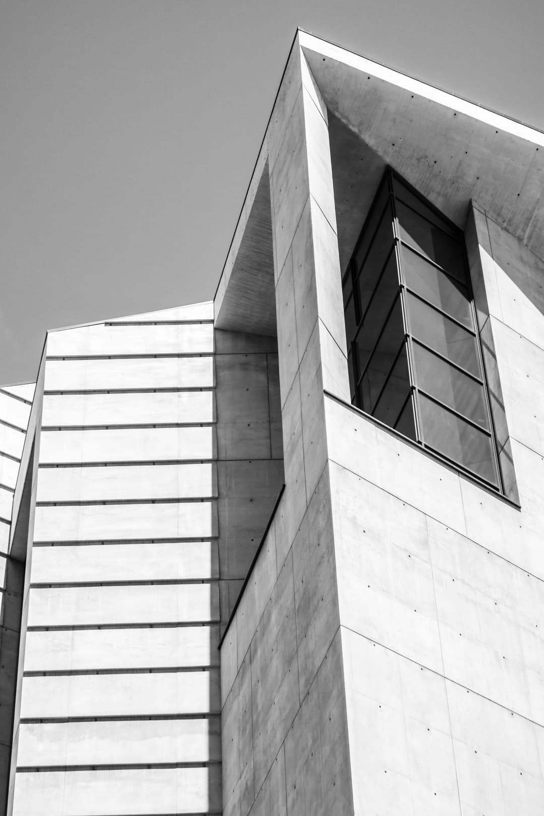Low-angle exterior view of the cathedral's angular concrete facade and window.