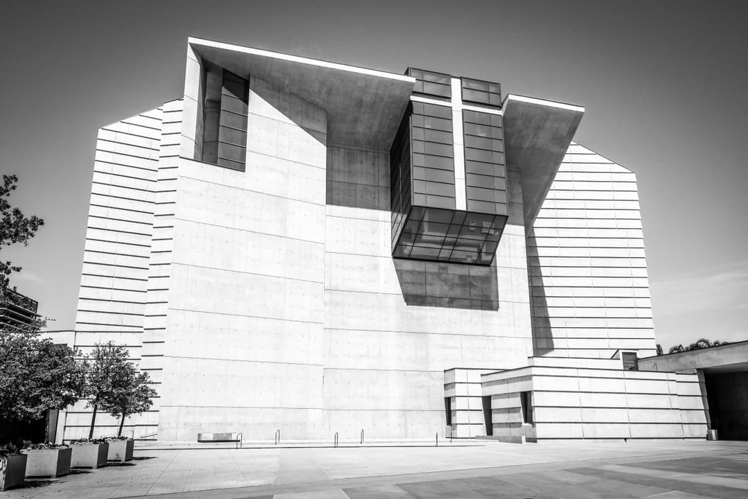 Exterior view of the main concrete facade and prominent glass cross.