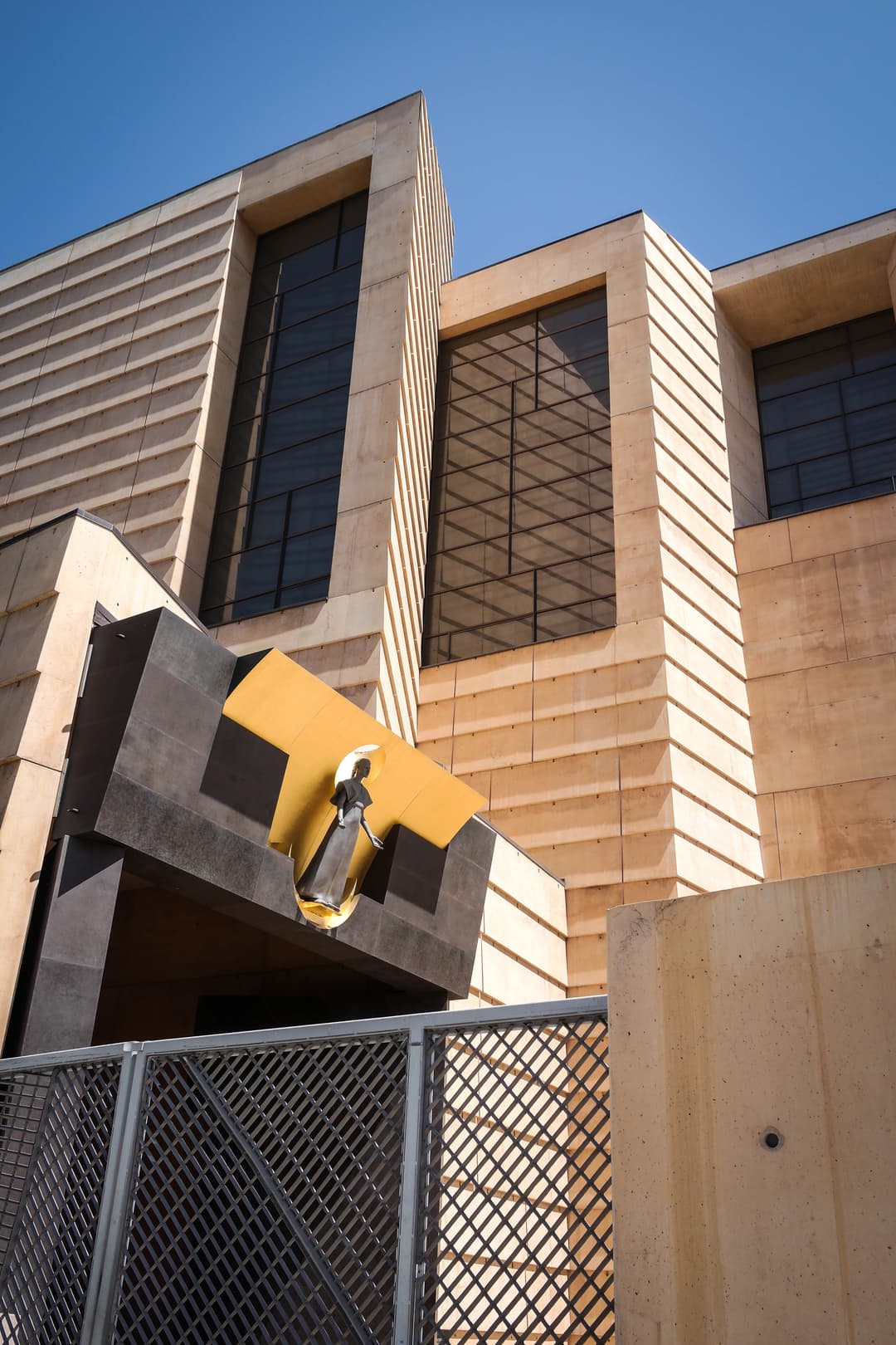 Low-angle exterior view of the entrance and statue of Our Lady of the Angels.