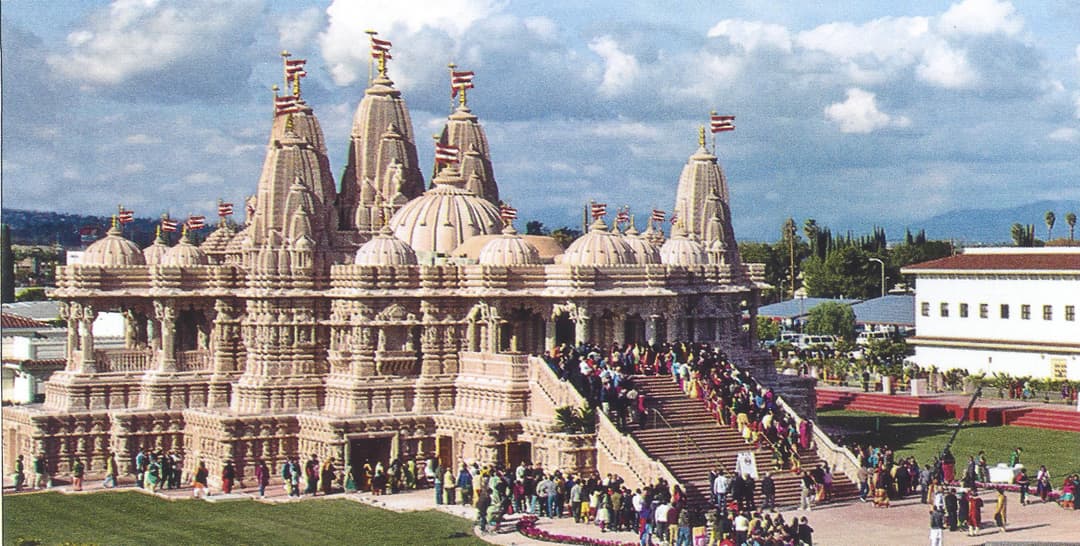 Exterior view showing the Mandir's spires, domes, and grand entrance stairs.