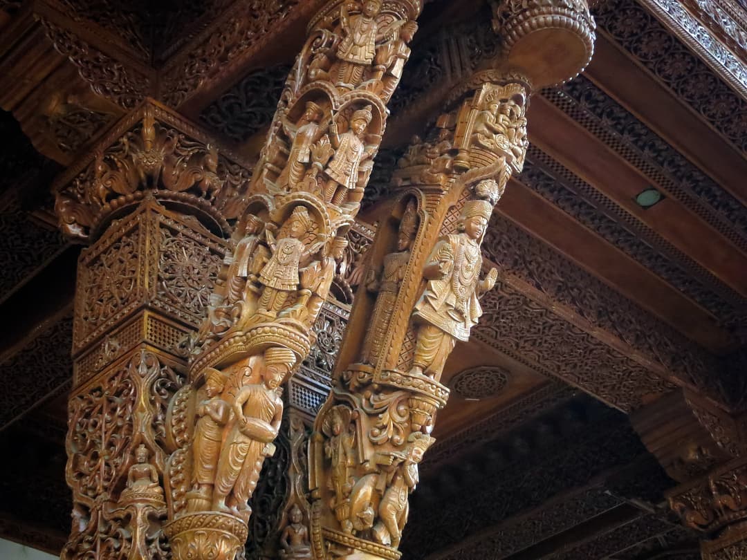 Intricately carved wooden pillars in the temple interior.