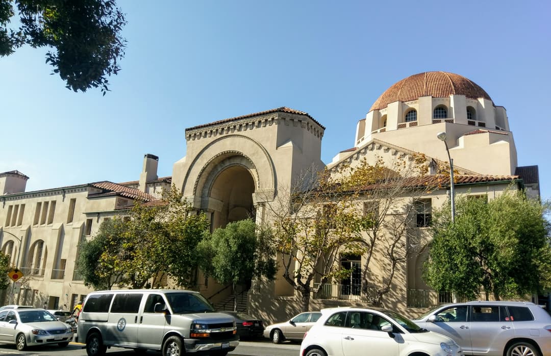 Street view of the arched entry portal and dome of Congregation Emanu-El