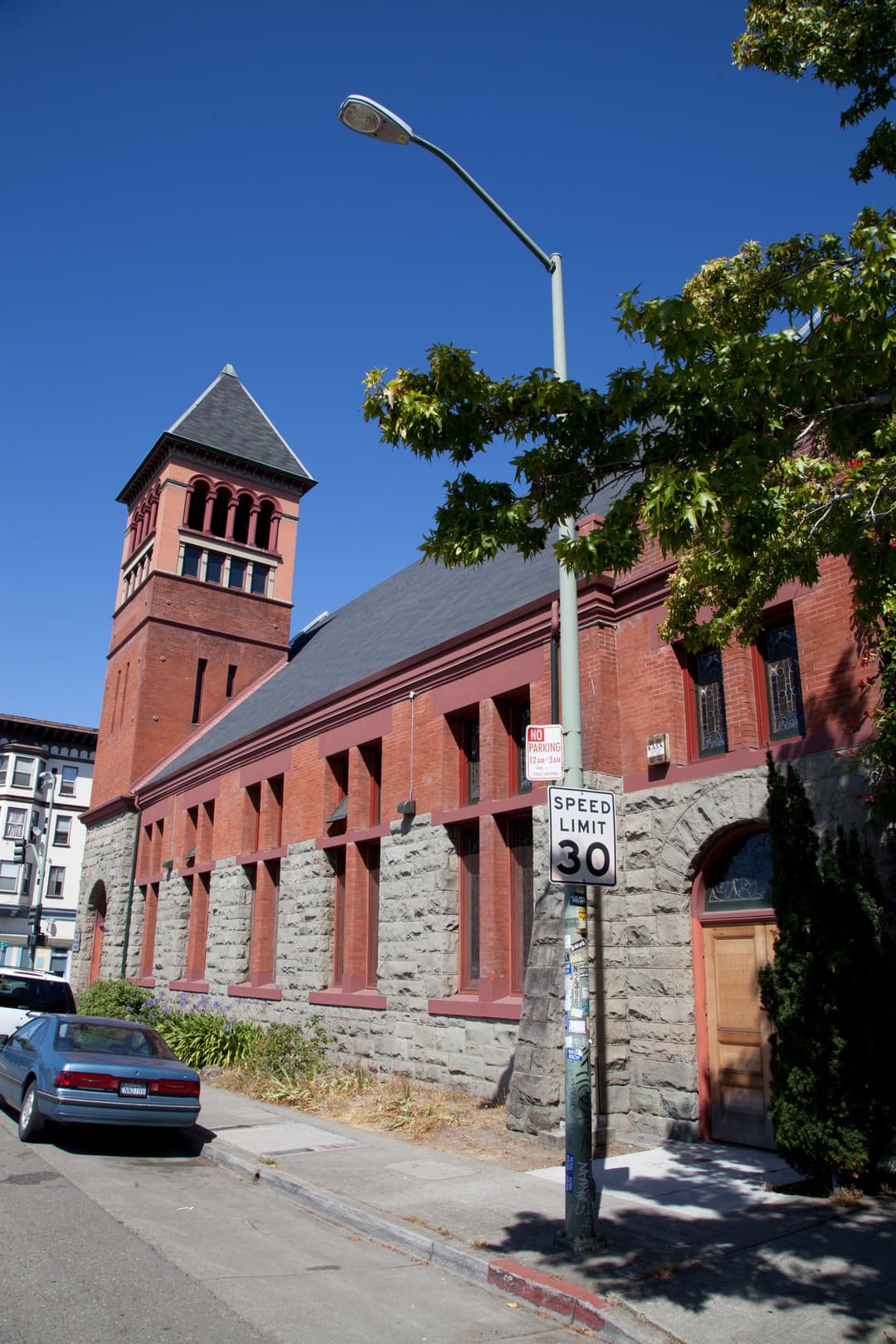 Exterior street-level view of the facade and bell tower in daylight