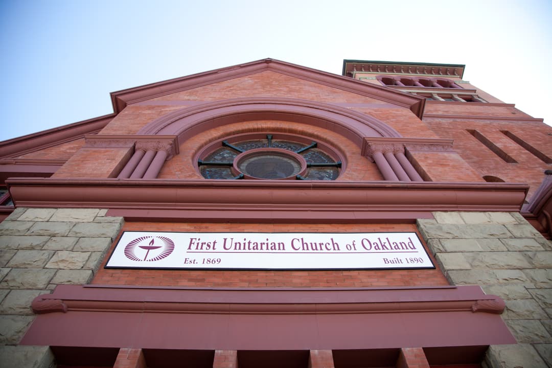 Low-angle view of the front entrance sign and brick gable facade.