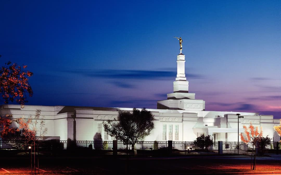 Fresno California Temple at twilight, featuring its single spire and Angel Moroni.