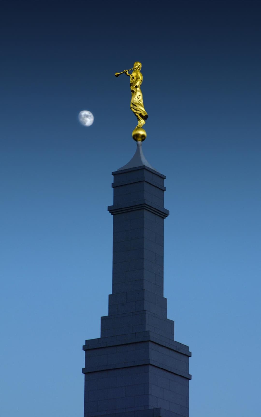 Low-angle view of Fresno California Temple spire, Angel Moroni, and moon.
