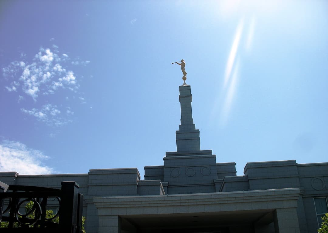 Upward view of Fresno California Temple spire, Angel Moroni, and sun flare.