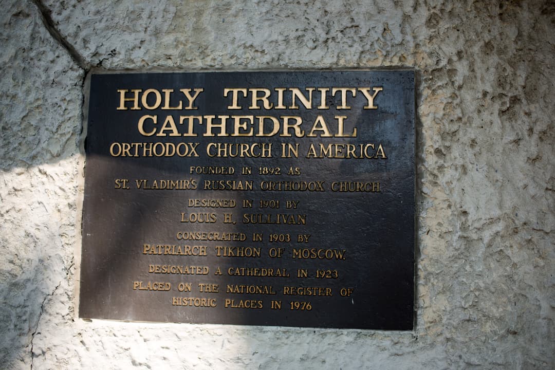 Historic bronze dedication plaque on the exterior wall.