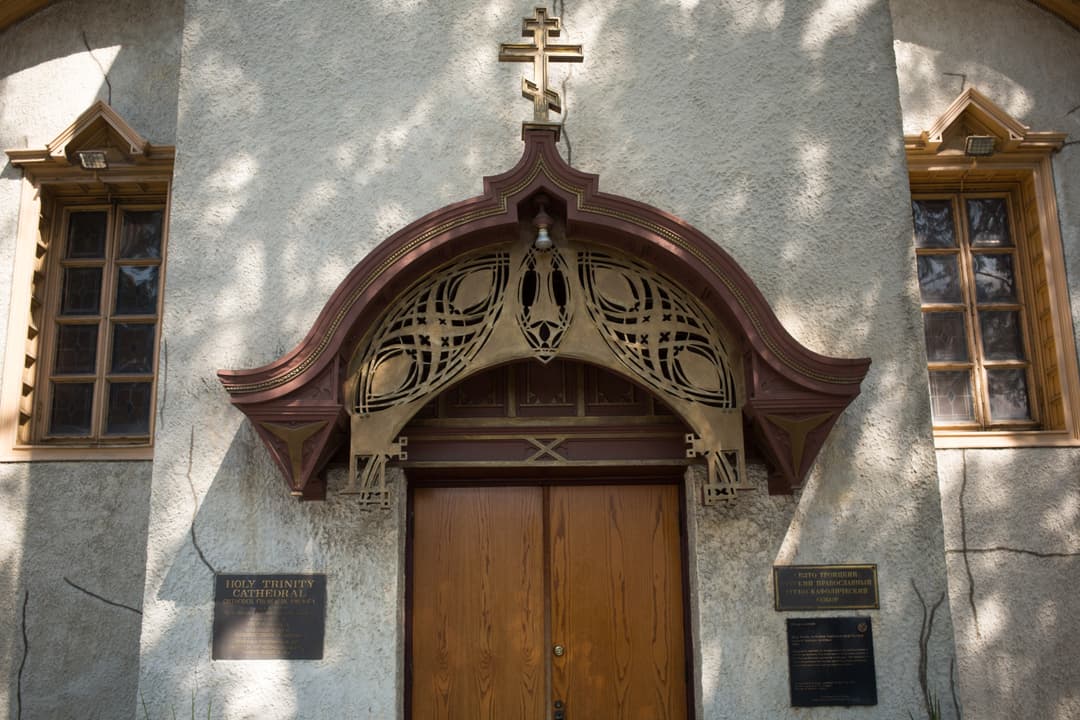 Front entrance with ornate canopy and Orthodox cross