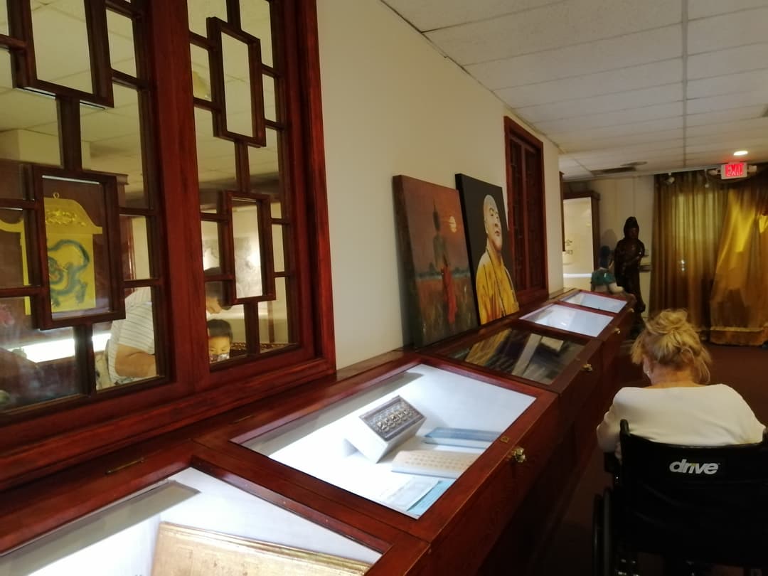 Interior view of the museum gallery featuring wooden display cases and artwork.
