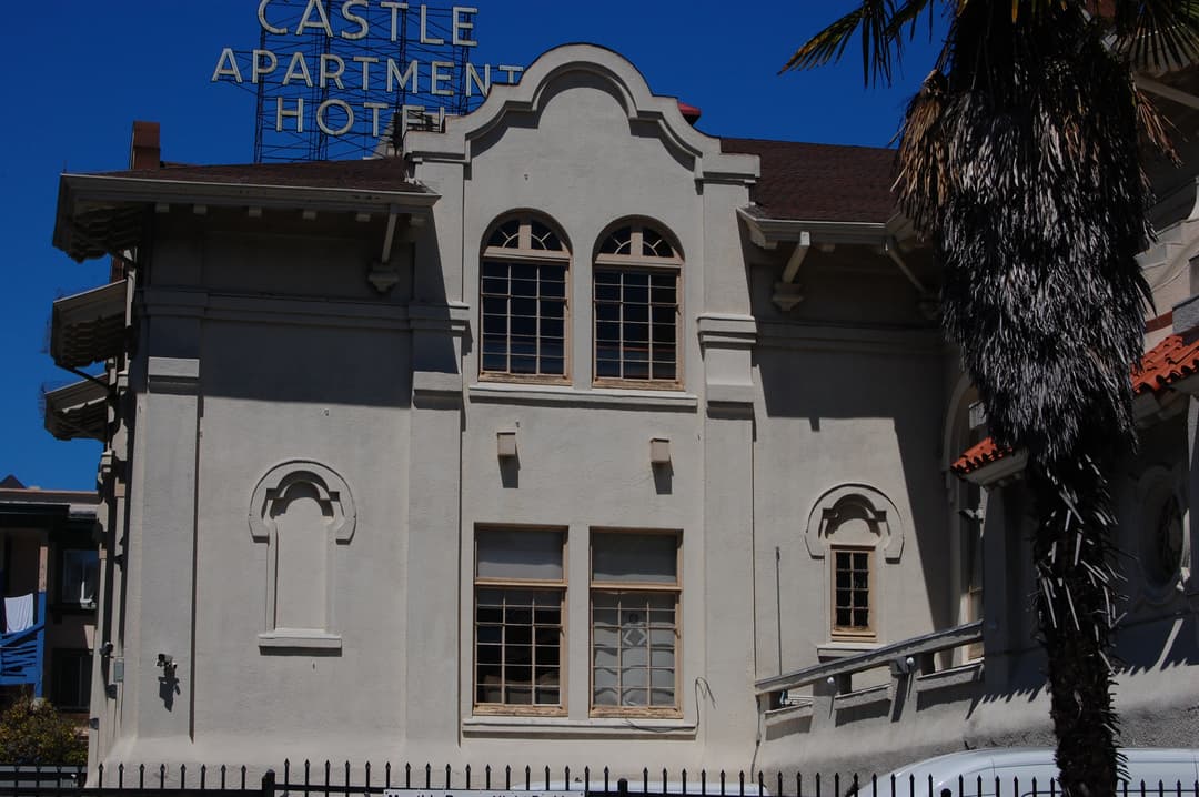 Exterior facade detail with Mission Revival parapet in bright daylight