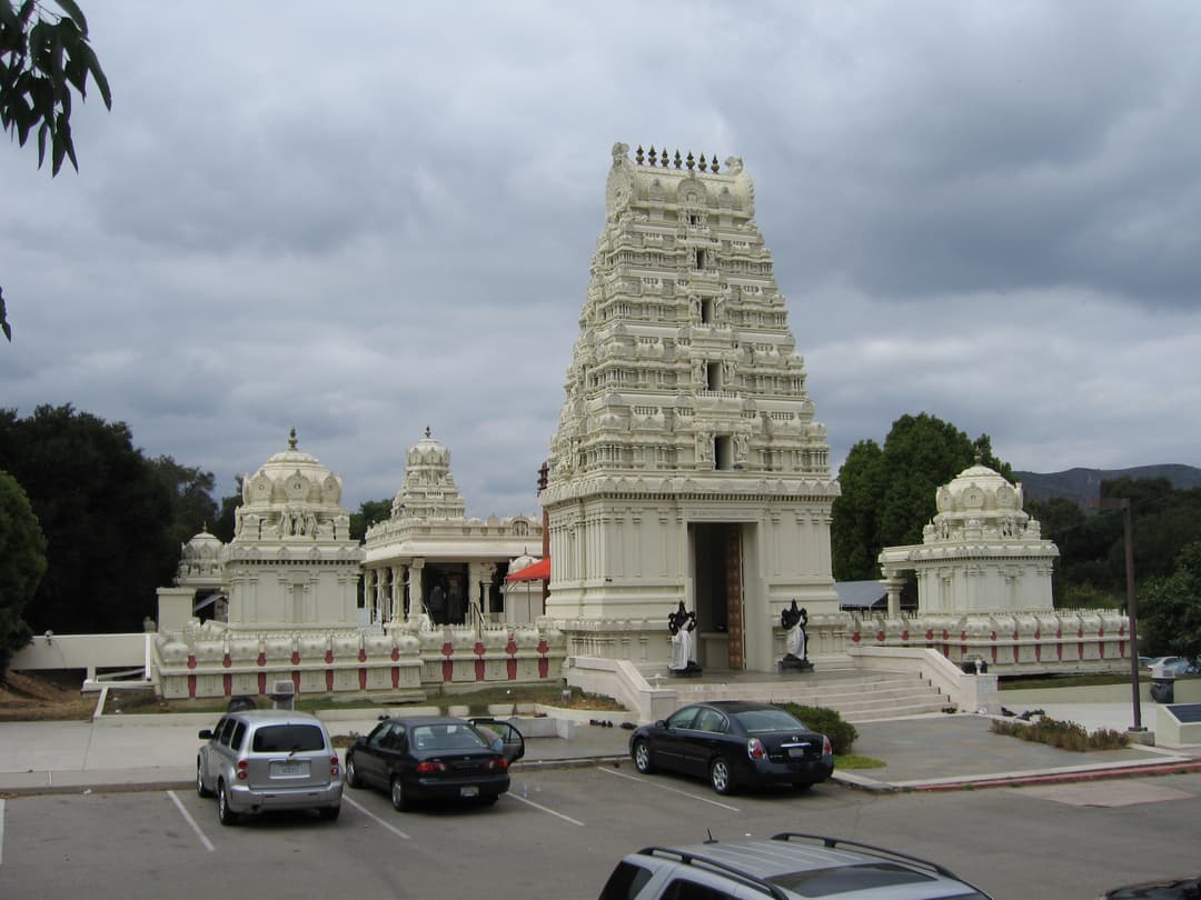 Main entrance gopuram and shrines viewed across the parking lot.
