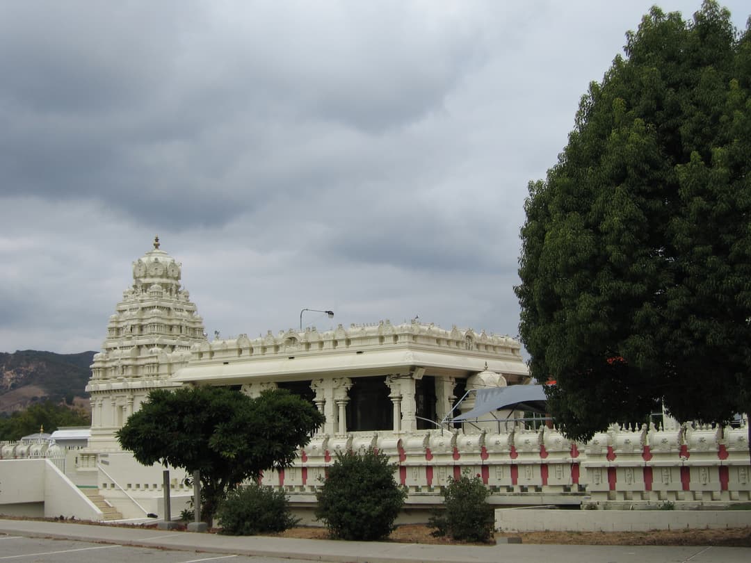 Exterior view of the temple pavilion and vimana under an overcast sky.