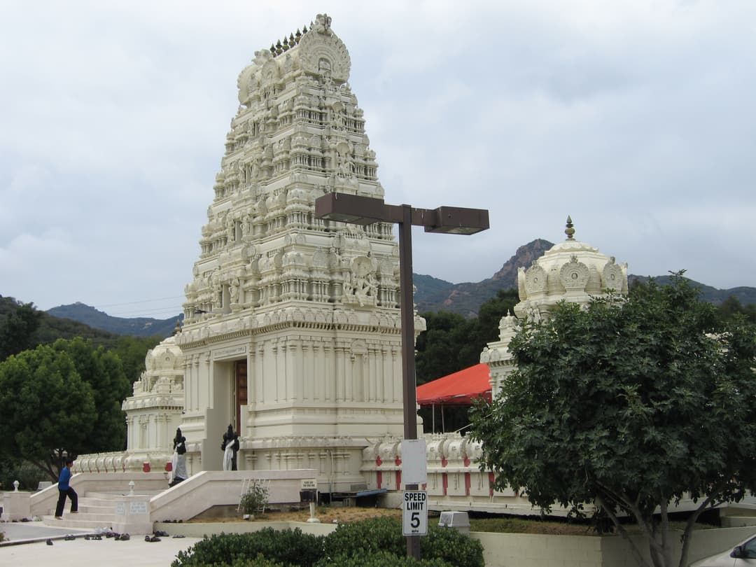Exterior view of the ornate white gopuram and entrance steps.