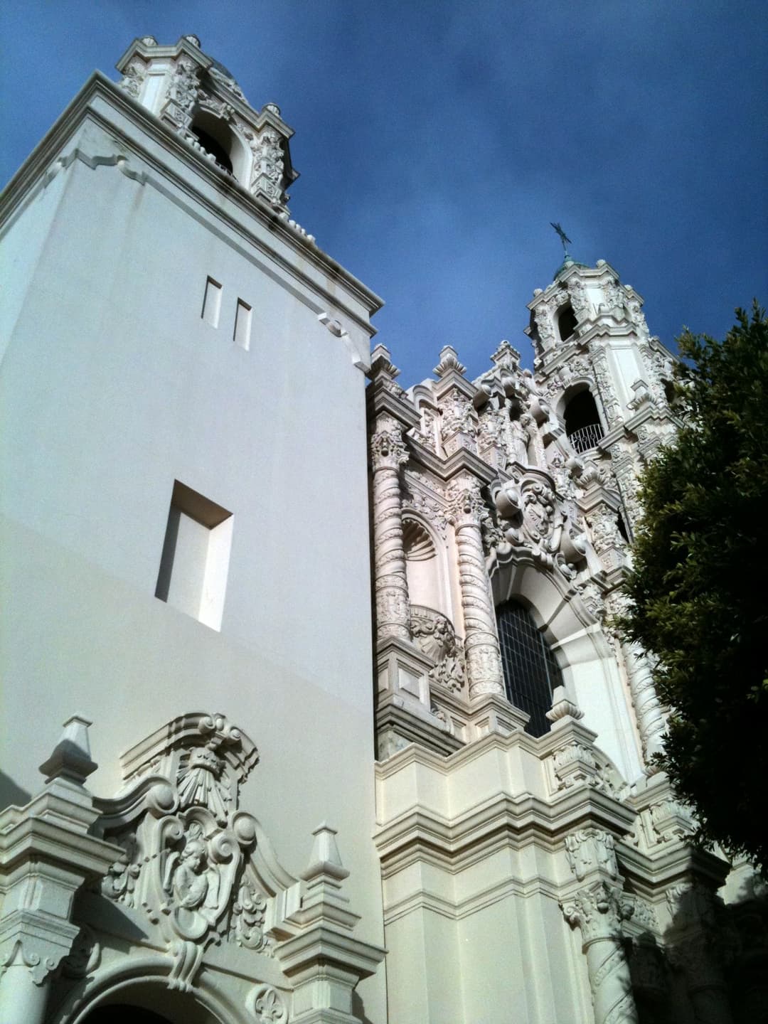 Low-angle view of the ornate Mission Dolores Basilica facade and bell tower.