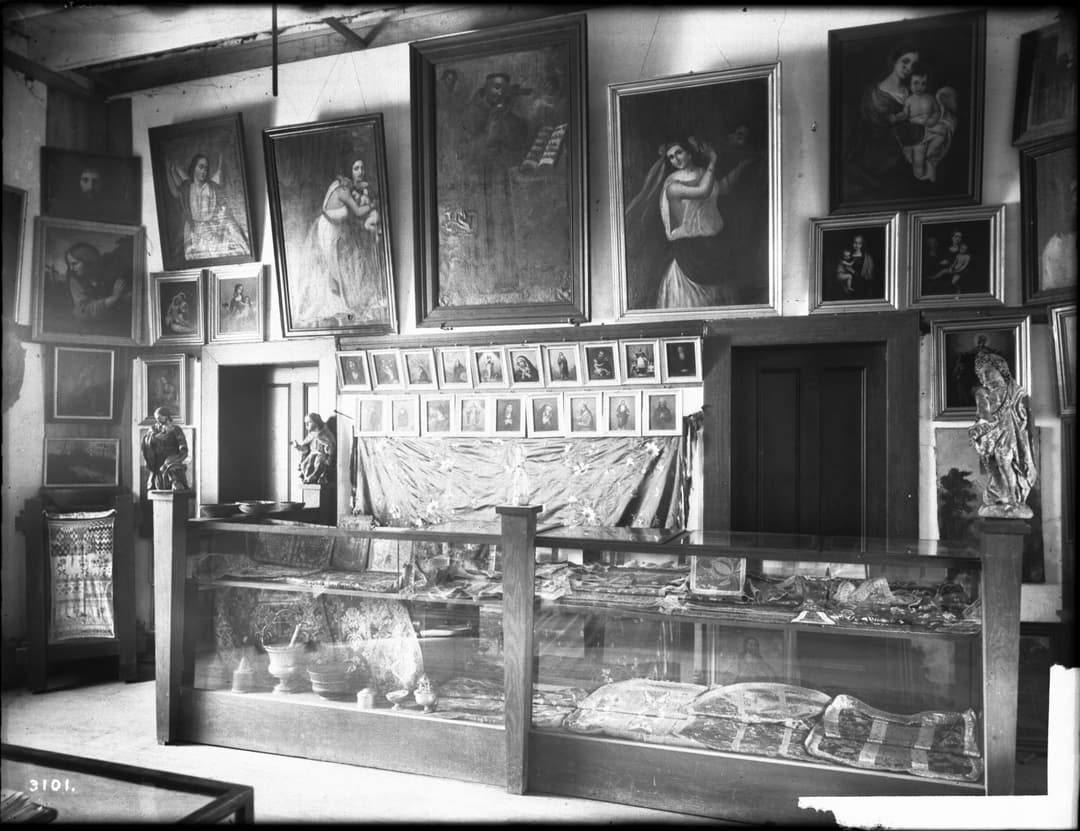 Interior view of the museum gallery with paintings and display cases.