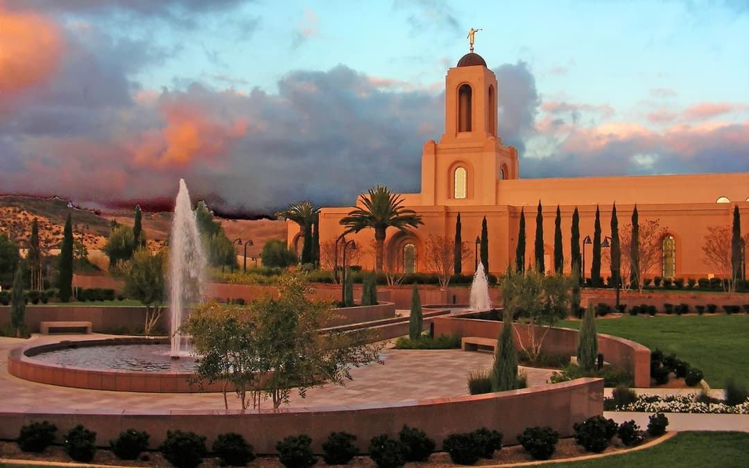 Newport Beach Temple at sunset, with fountains and landscaped grounds.