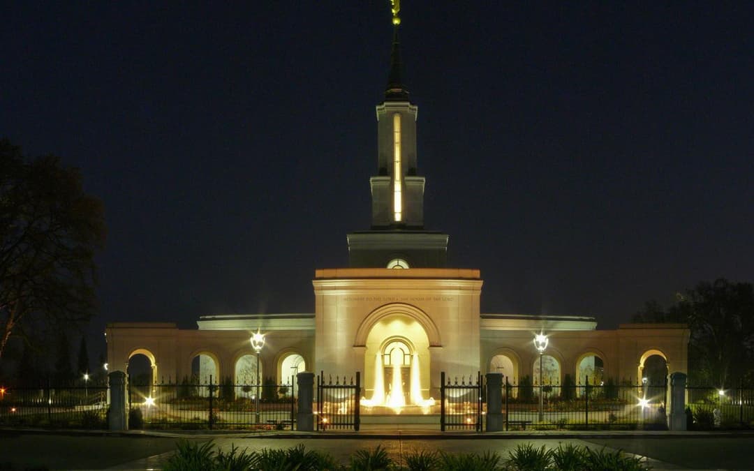 Front view of the illuminated Sacramento California Temple at night.