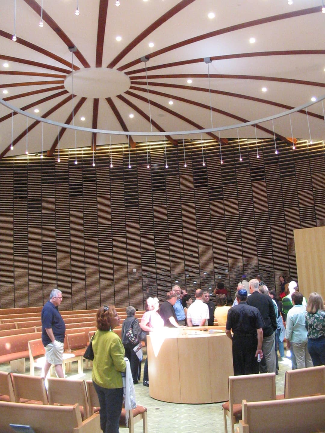 Interior view of the sanctuary with a radial ceiling and slatted wood wall.