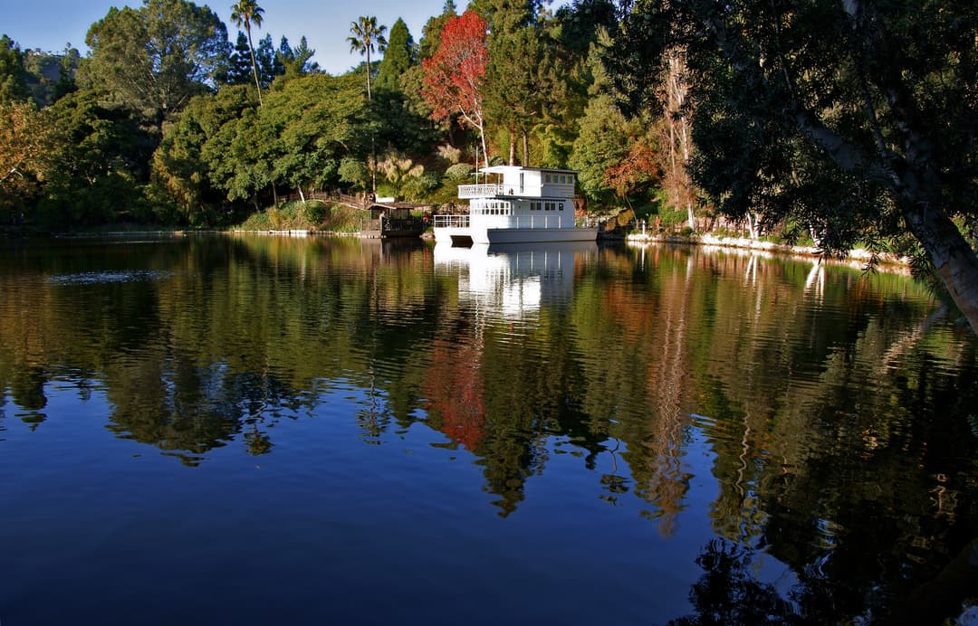 Wide view of the white houseboat on the serene lake.