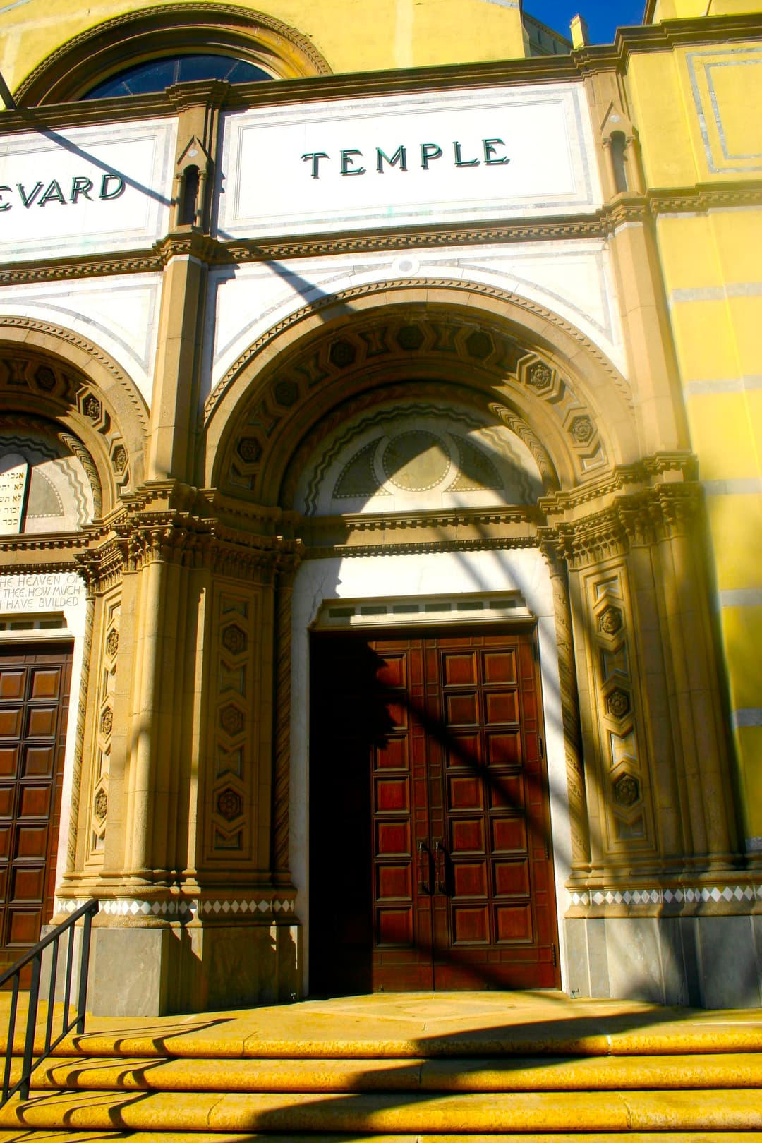 Front entrance portal with carved stone arch and wooden doors.