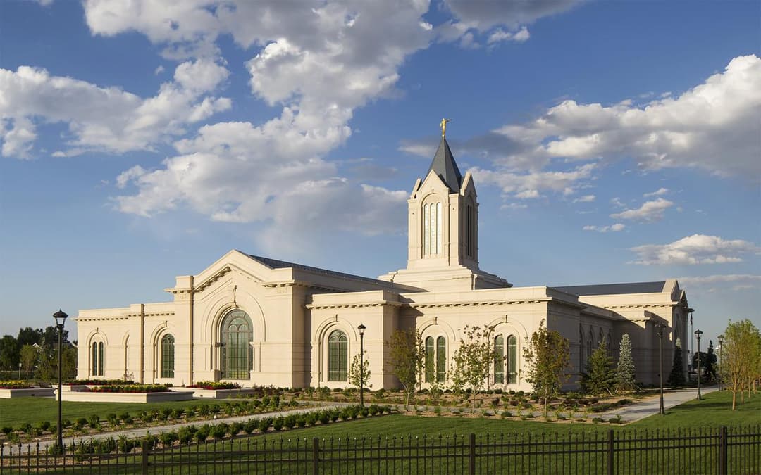 Fort Collins Colorado Temple exterior with spire and Angel Moroni in evening light.