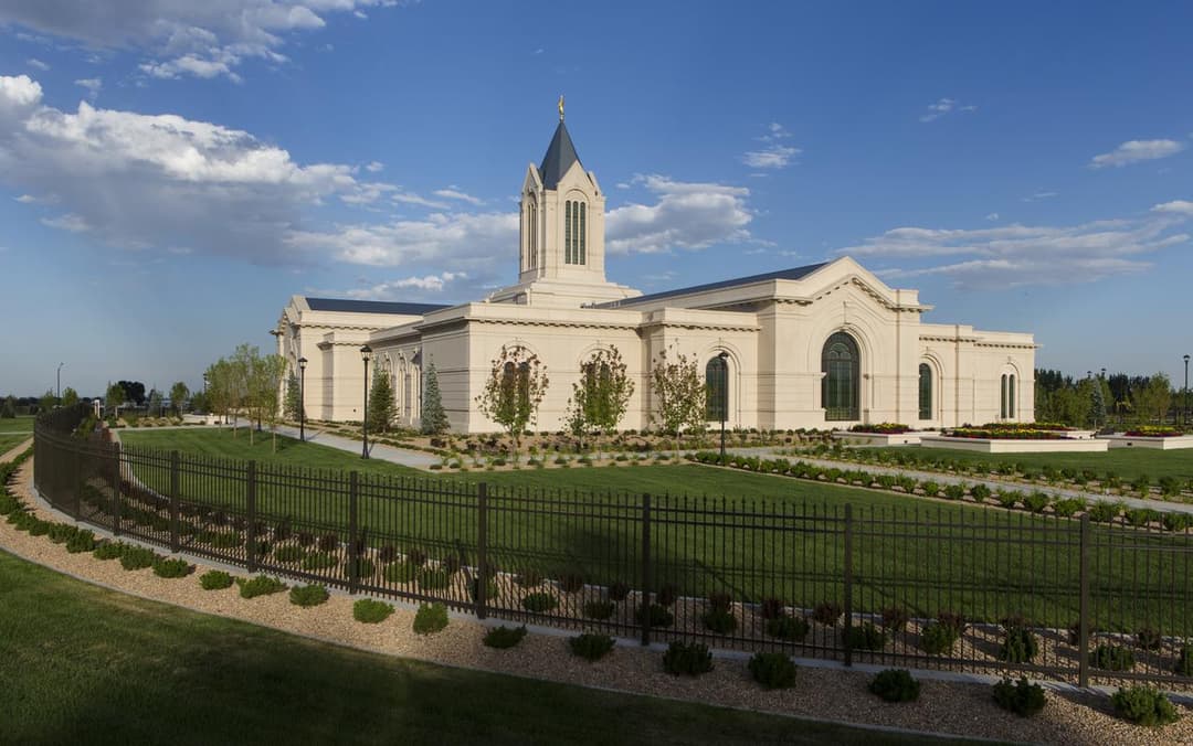 Fort Collins Colorado Temple exterior, showing spire, fence, and landscaped grounds.