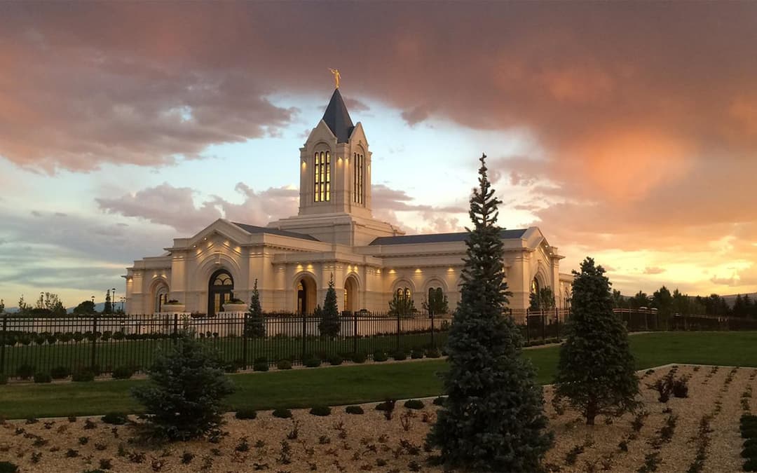 Fort Collins Colorado Temple at twilight, with Angel Moroni and landscaped grounds.