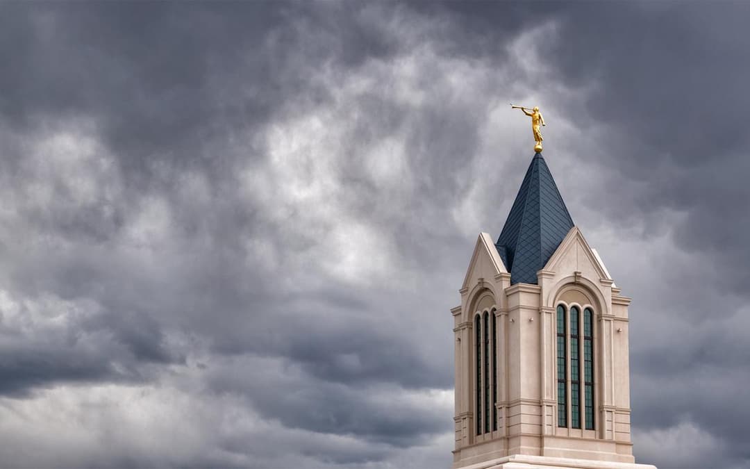 Angel Moroni statue atop the Fort Collins Colorado Temple spire under a cloudy sky.