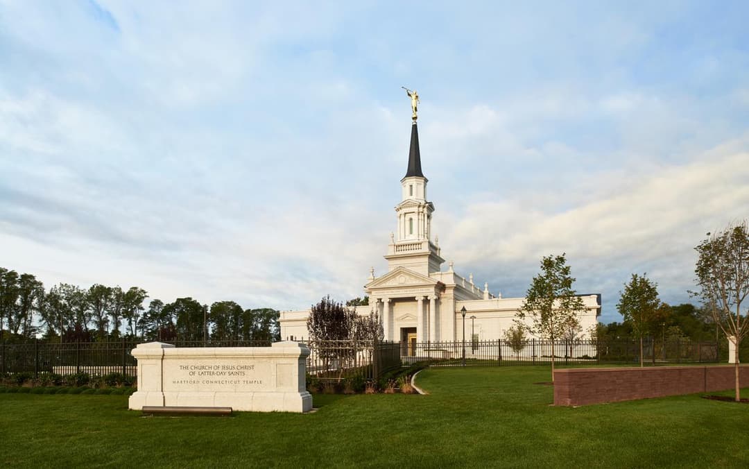 Hartford Connecticut Temple exterior, wide shot with spire, Angel Moroni, and monument.