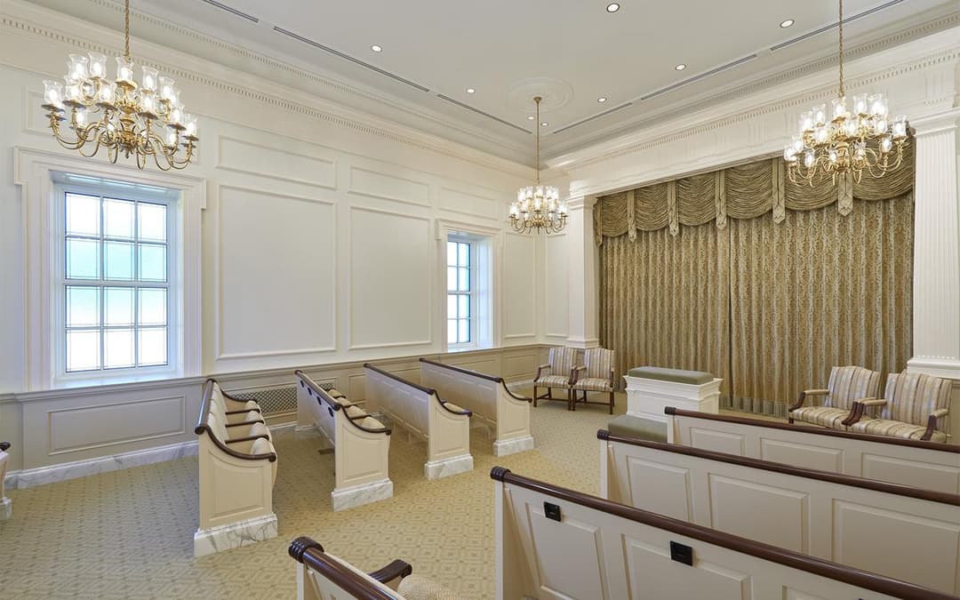 Interior room with formal seating, chandeliers, and elegant drapery.