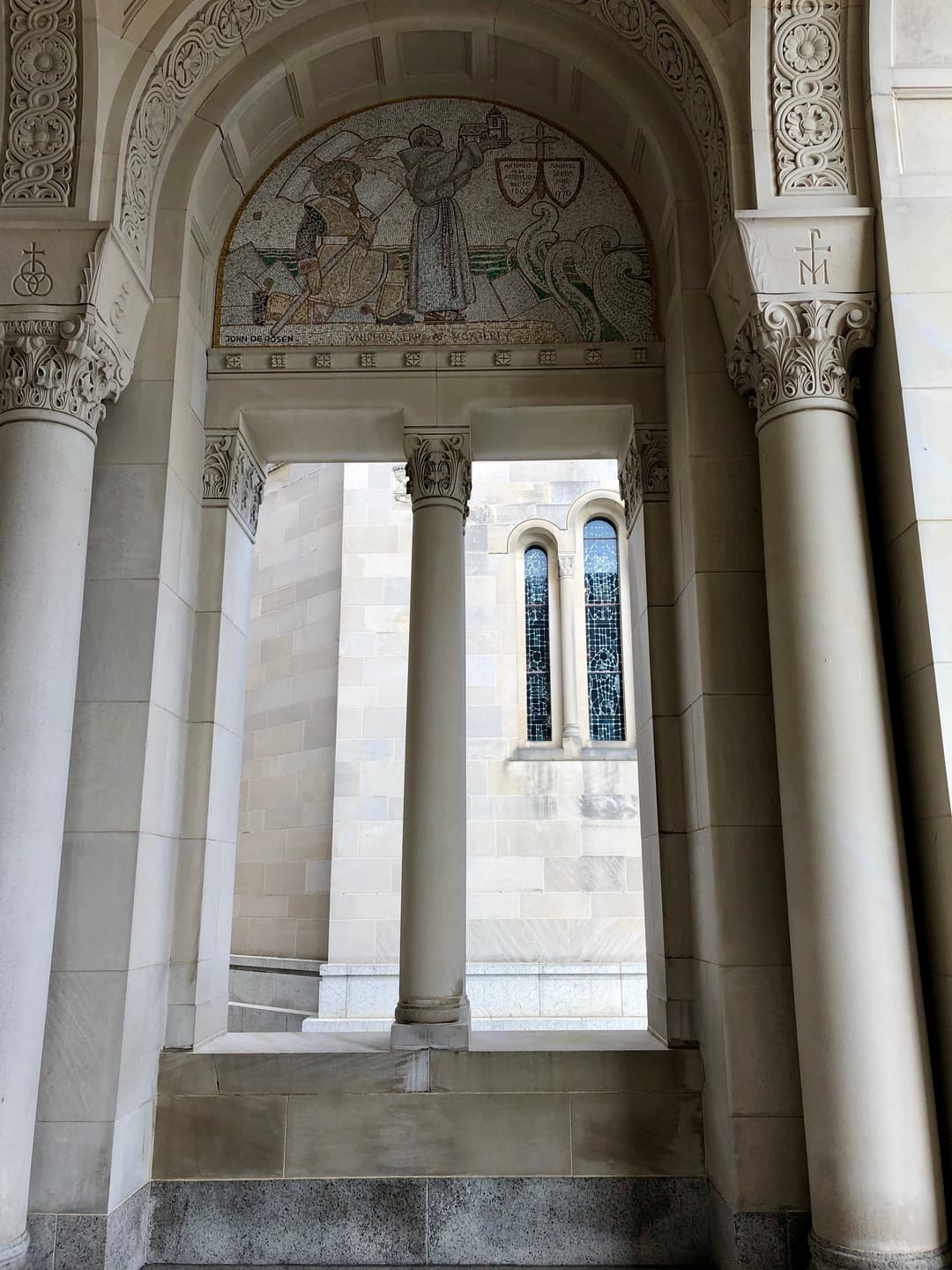 Stone archway framing a Jan Henryk de Rosen mosaic of St. Junípero Serra.