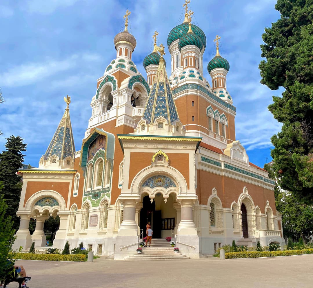 Exterior view of the ornate entrance, spires, and patterned onion domes