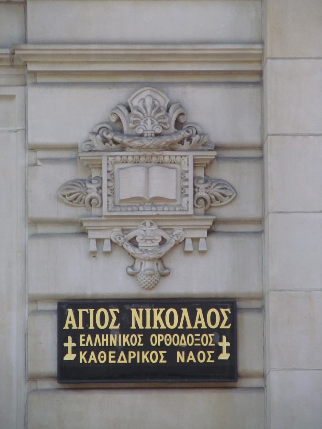 Carved relief and Greek sign on the cathedral exterior.