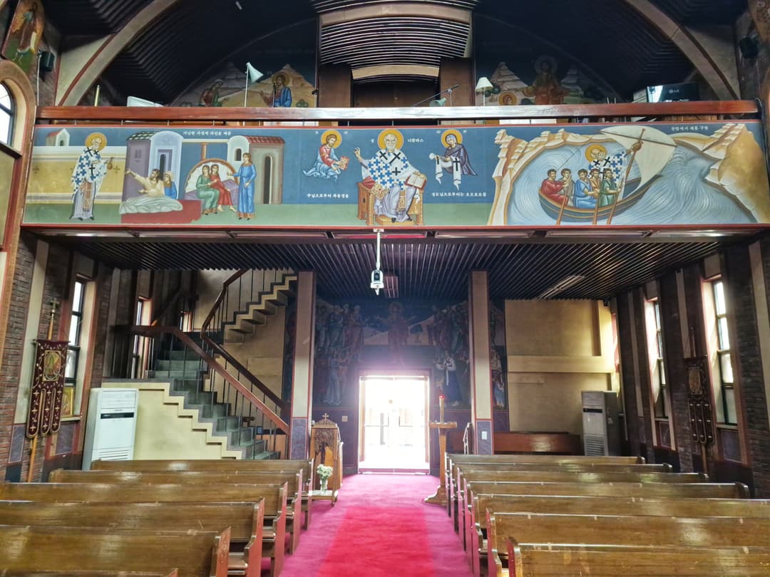 Interior view facing the entrance and choir loft with murals