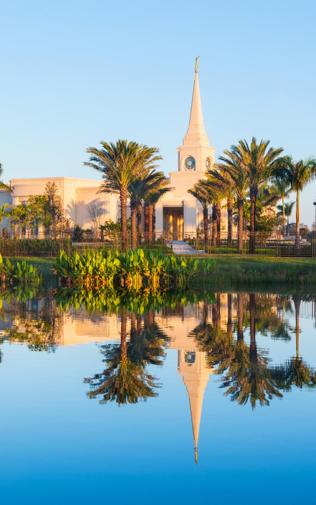 Fort Lauderdale Florida Temple at golden hour, reflected in water with palms.
