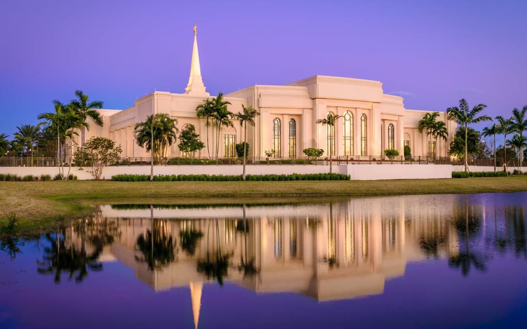 Fort Lauderdale Florida Temple exterior at dusk, with spire and water reflection.