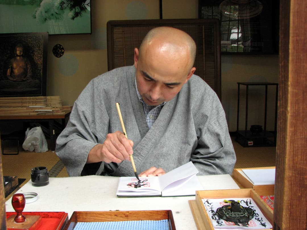 A calligrapher inscribing a goshuin stamp book at Byodo-In Temple.