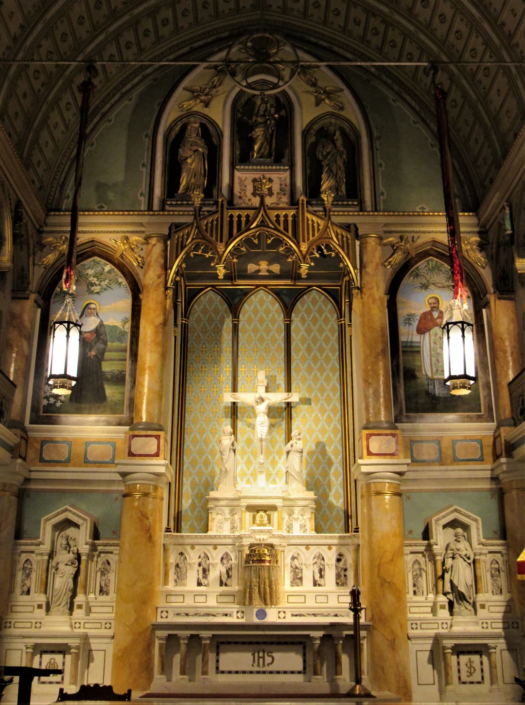 High altar and reredos with murals of St. Damien and St. Marianne