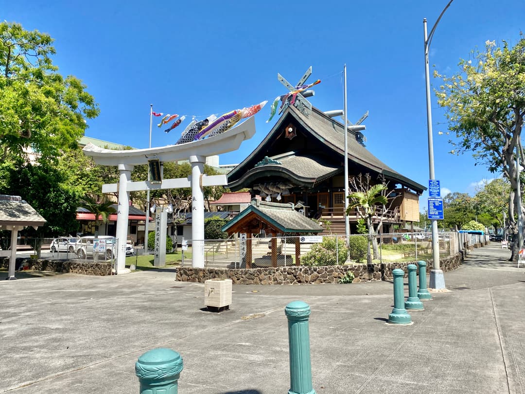 Wide view of the white torii gate and sanctuary with carp streamers