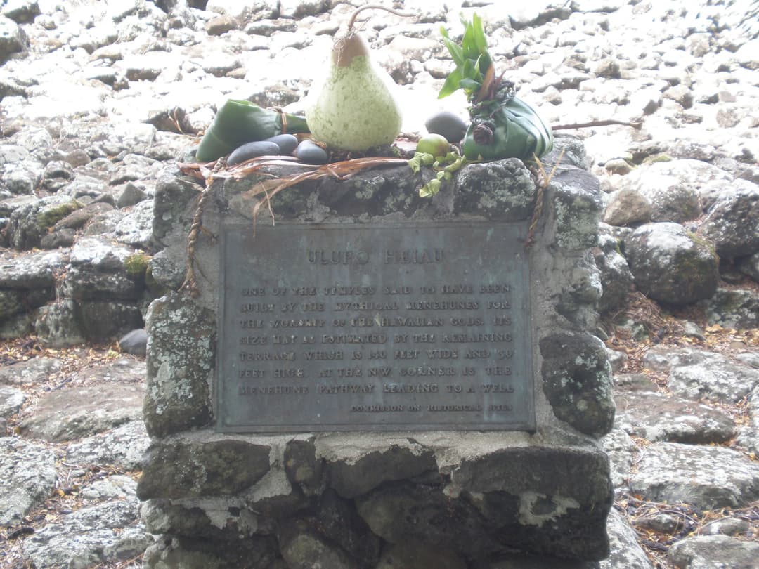 Historical marker plaque with traditional offerings at Ulupō Heiau.