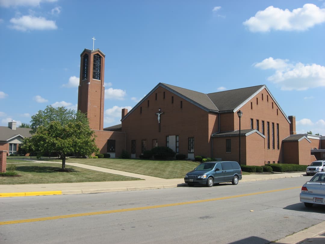 Street view of the church exterior and tall brick bell tower