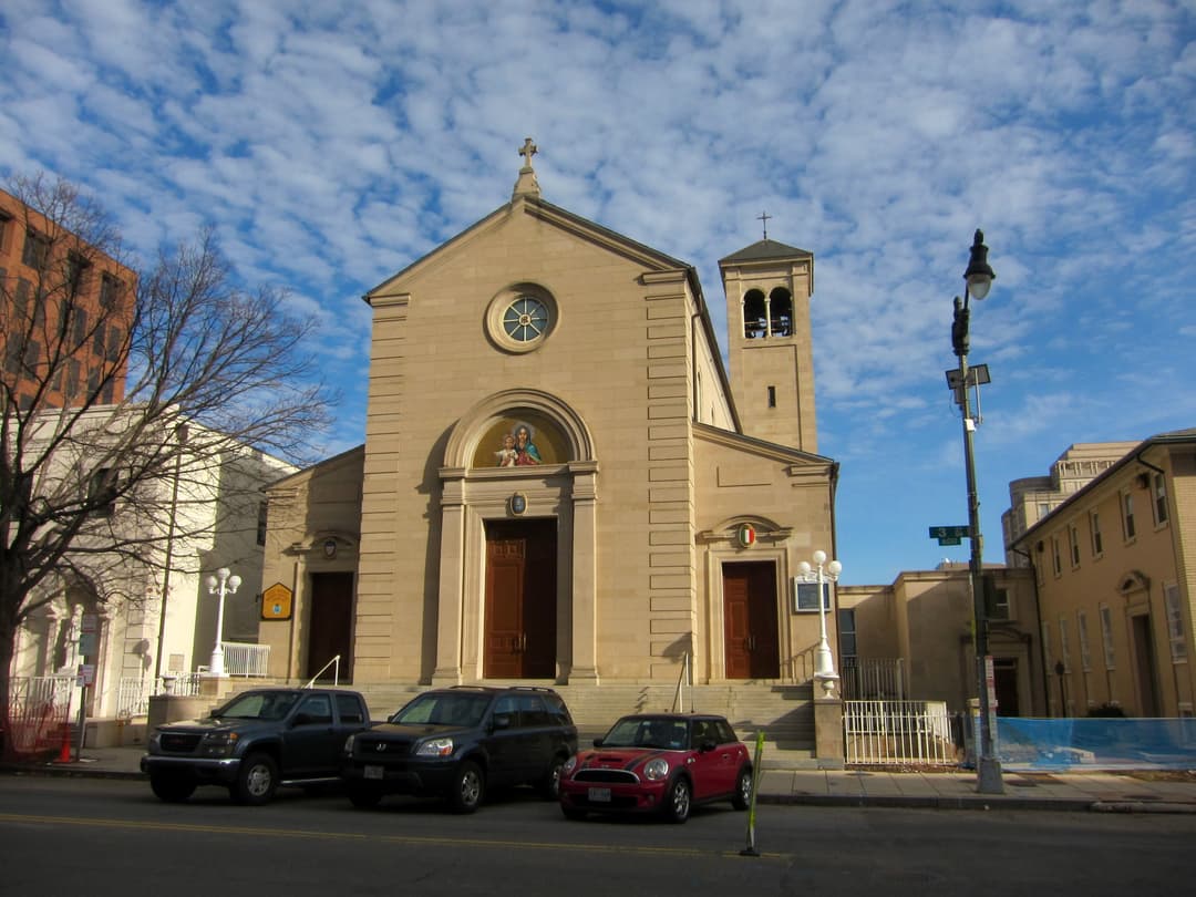 Front entrance and bell tower under a partly cloudy blue sky